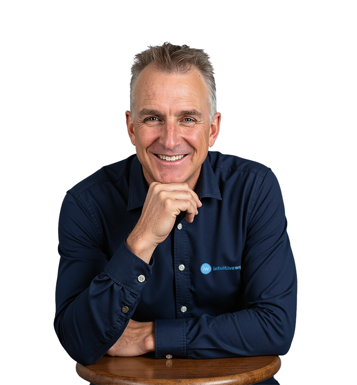 Ray Cameron, smiling and seated, wearing a navy blue Intuitive Websites shirt against a neutral background