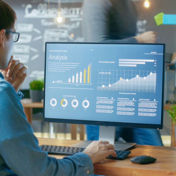 Marketer reviewing digital marketing campaign analytics on a computer screen in a modern office